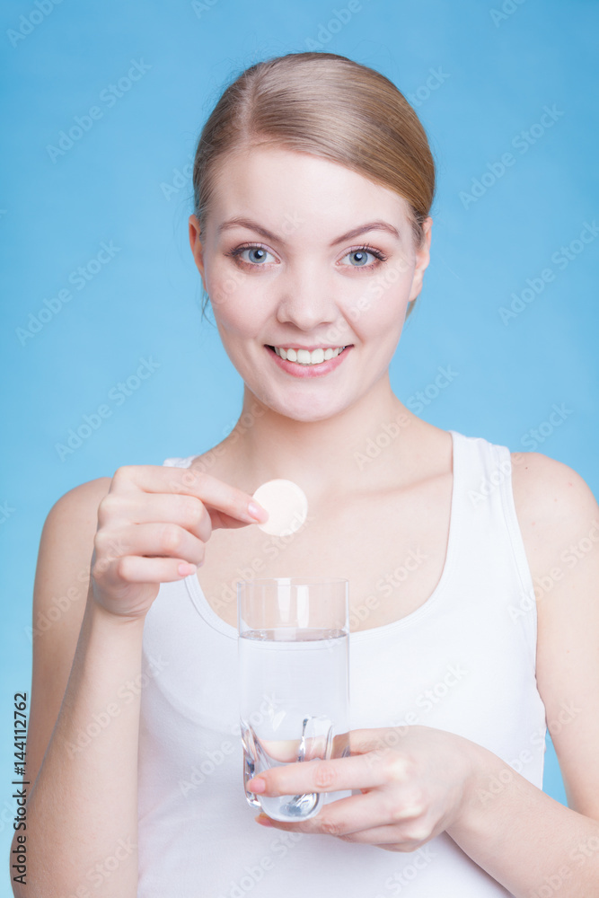 Woman holding glass with water and effervescent tablet Woman holding glass with water and effervescent tablet