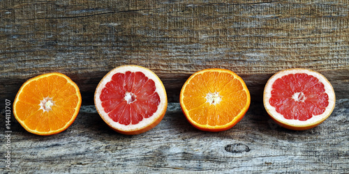 Schilderij op canvas Gesunde, saftige Orangen und Grapefruit auf Holzuntergrund in Format 18:9