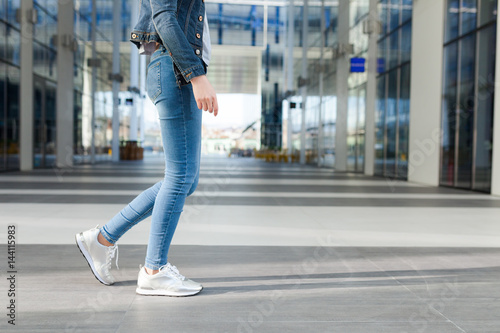 Detail of a woman's legs, wearing jeans, dynamic view. Outdoor concept for modern outdoor or lifestyle activities.