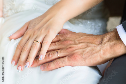 Hands of the groom and the bride with wedding rings