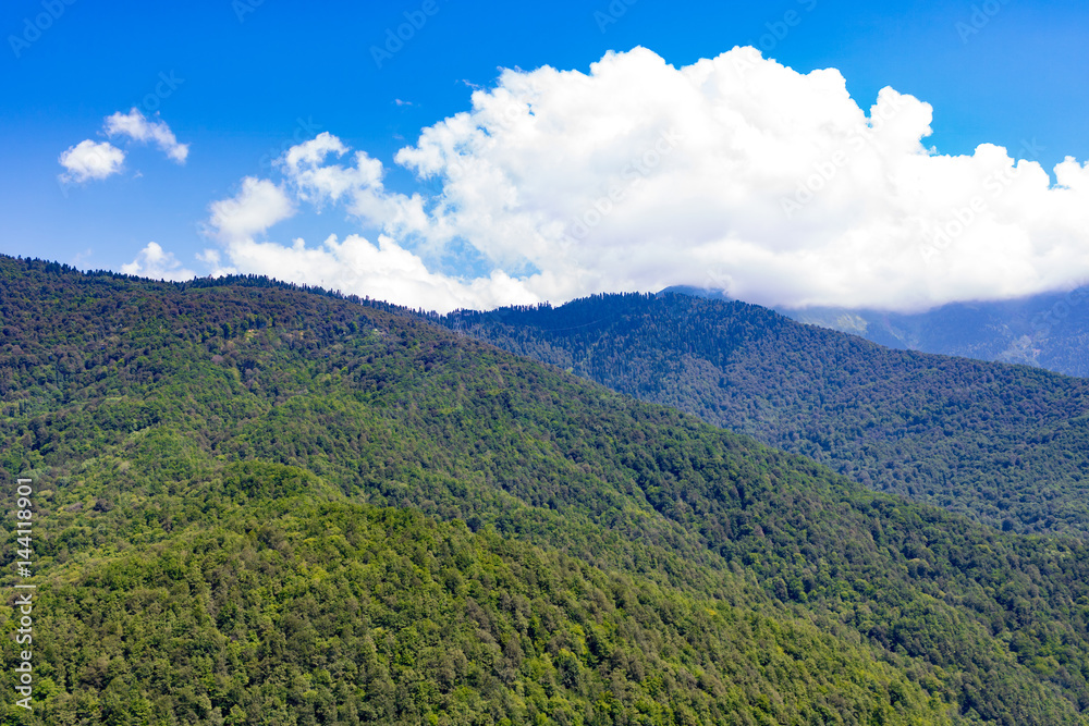 Mountains and clouds in a bright blue sky. Mountains and clouds in a bright blue sky.