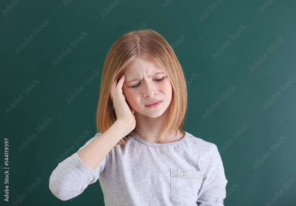 Cute girl suffering from headache on color background Cute girl suffering from headache on color background