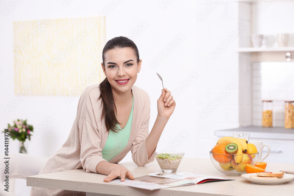 Beautiful young woman having breakfast in kitchen Beautiful young woman having breakfast in kitchen