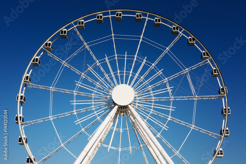White Ferris wheel over a blue sky