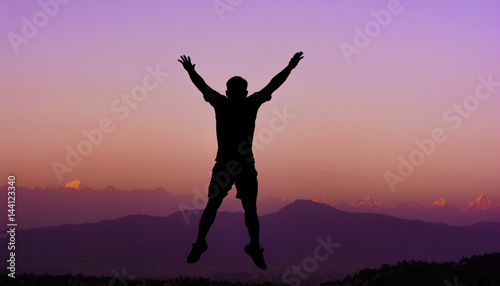 Silhouette of a happy man enjoying his trip in Nepal with blurred himalayan range on background