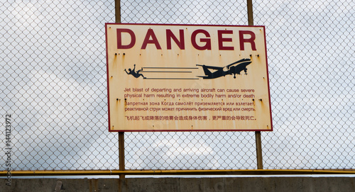 Sign warning of the dangers of jet wash from aircraft landing and taking off from a nearby runway photo