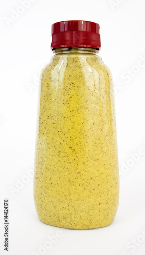 Isolated plastic squeeze bottle of spicy brown mustard with red cap. Vertical.