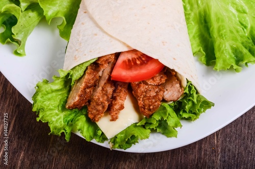 Burito with meat. Fried pork, beef, tomatoes