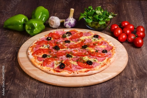 Thin pizza with ham and tomatoes