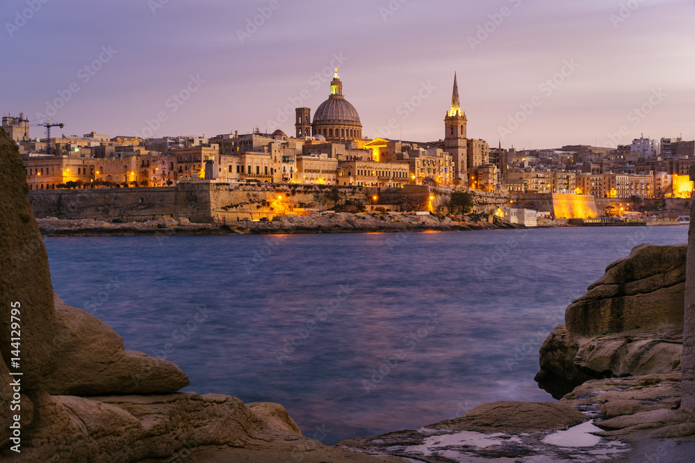 Valletta seafront at sunset with Basilica of Our Lady of Mount Carmel, viewed from Sliema, Malta