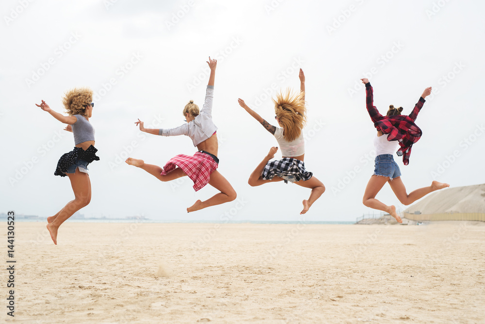 Young women in summer fashion outfit jumping in water. Young women in summer fashion outfit jumping in water.