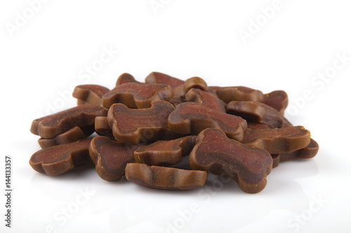 Pile of dog treats on a white surface. Dog cookies isolated on a white background.