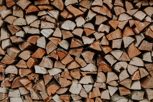 Woodpile of cut trees in the lumberyard. Background and texture with space for text or image. Fire wood prepared for winter. 