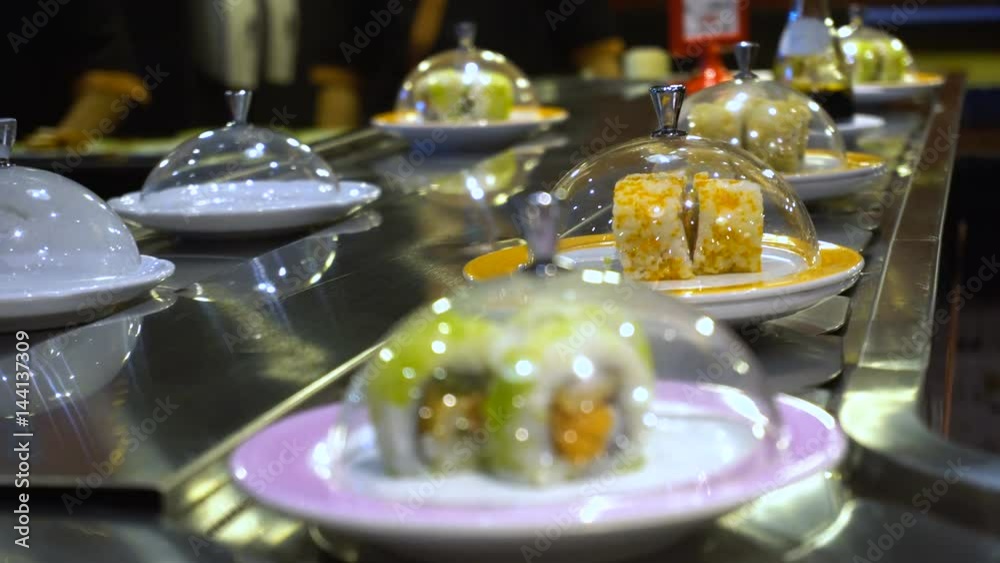 Dishes of Sushi and Sashimi rolling on conveyer belt Dishes of Sushi and Sashimi rolling on conveyer belt