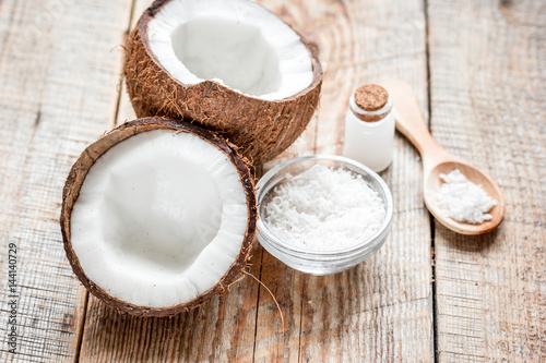 fresh coconut with cosmetic oil in jar on wooden background