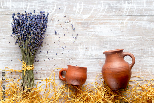 dry laveder bouquet and pottery jars on rustic background top view mockup photo