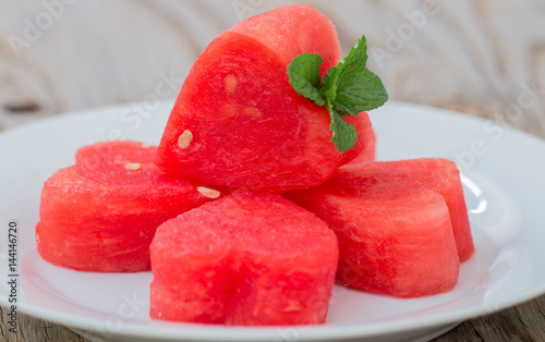 Watermelon on  white plate and wooden background. photo