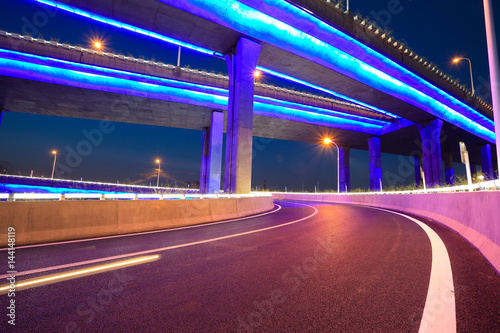 Empty road floor with city viaduct bridge of neon lights night