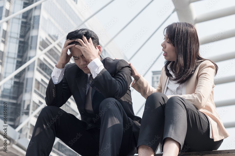 Wall Mural The woman caring the frustrated businessman with failed business sitting on the