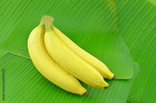 Banana is placed on a green banana leaf.
