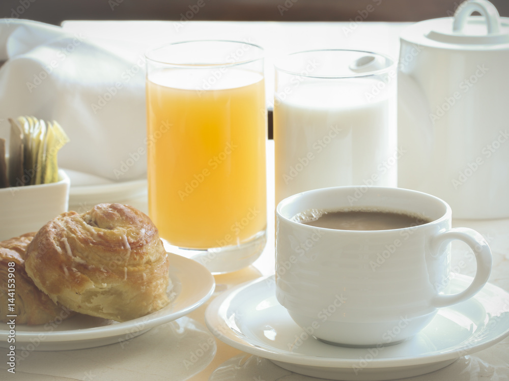 coffee, cinnamon roll, toast, milk and orange juice for breakfast.