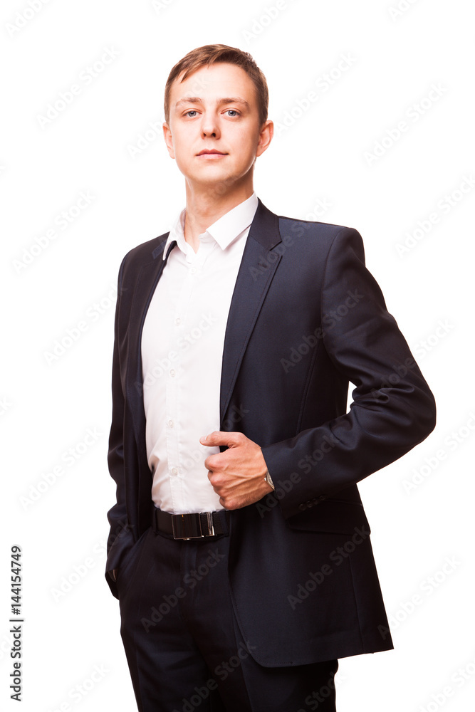 Young handsome businessman in black suit is standing straight and putting his hands in pockets, portrait isolated on white background