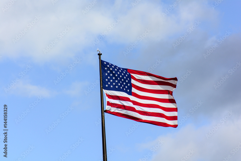 USA flag wave in the wind under blue sky
