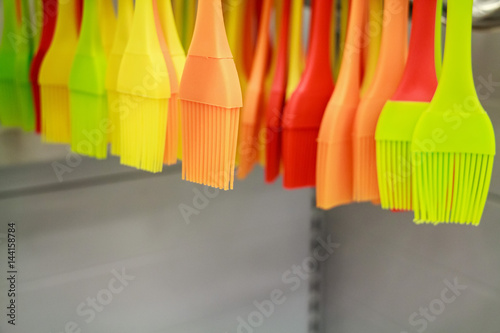 Colorful kitchen brushes hang in supermarket © greentellect