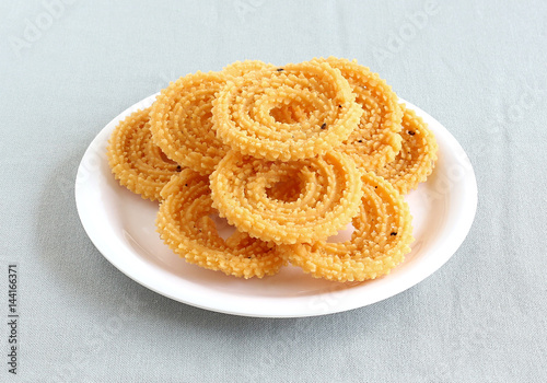 Chakli, also known as murukku, which is a south Indian traditional, popular and vegetarian snack, on a plate. photo