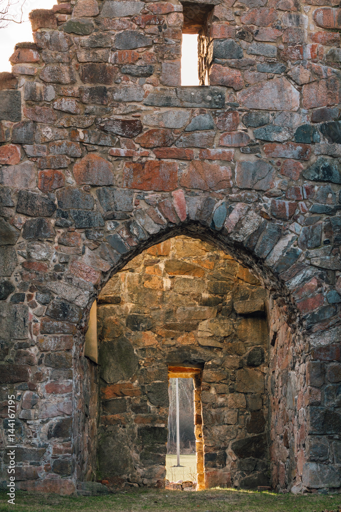 Main gate of a medieval church ruin made of stone located in Lundby Rytterne in Sweden.