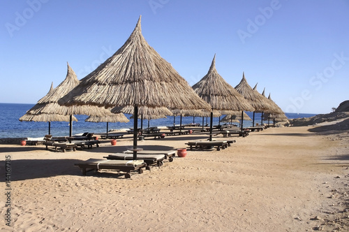Straw umbrellas on the sandy beach of Egypt