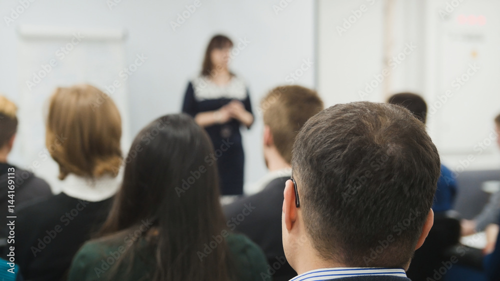 Blurred business concept background - a lot of people sitting at a seminar or lectures