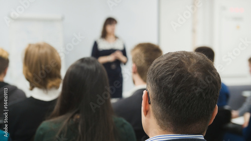 Blurred business concept background - a lot of people sitting at a seminar or lectures