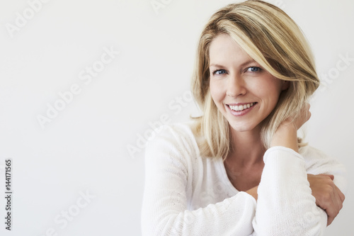Blue eyed blond woman smiling to camera