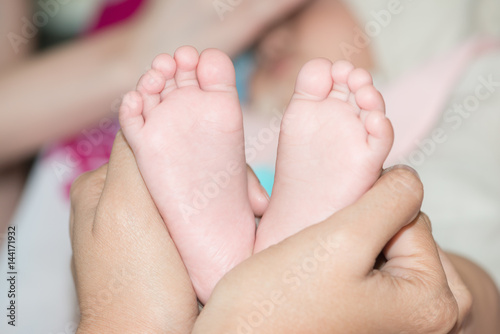 Mother hand hold baby toe © teen00000