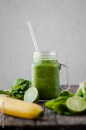 Detox drink with banana, spinach and lime in a glass jar