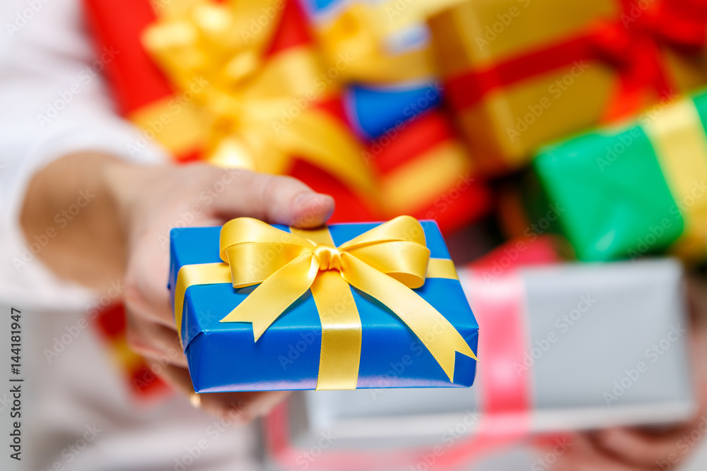 Male hands holding a gift boxes. Presents wrapped with ribbon and bow
