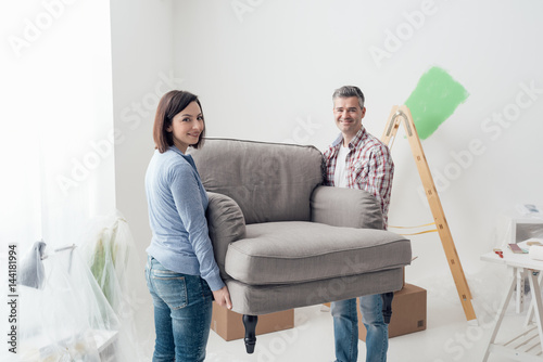 Couple moving furniture in their new house photo