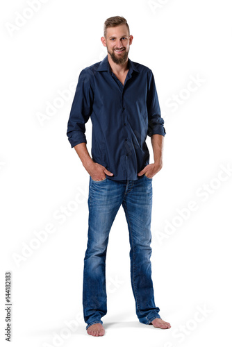 Portrait of tall young man with beard in blue shirt and jeans