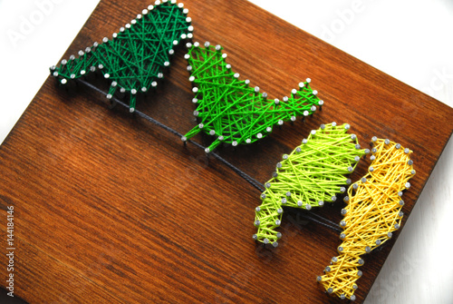 Birds made of thread on a wooden board