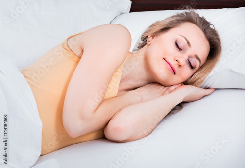 Woman in pyjamas having a nap in the bed