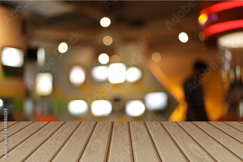 image of wooden table in front of abstract blurred background of cafe lights