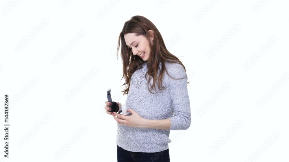 Smiling young pregnant woman holding headphones on her belly and dancing isolated over white Smiling young pregnant woman holding headphones on her belly and dancing isolated over white