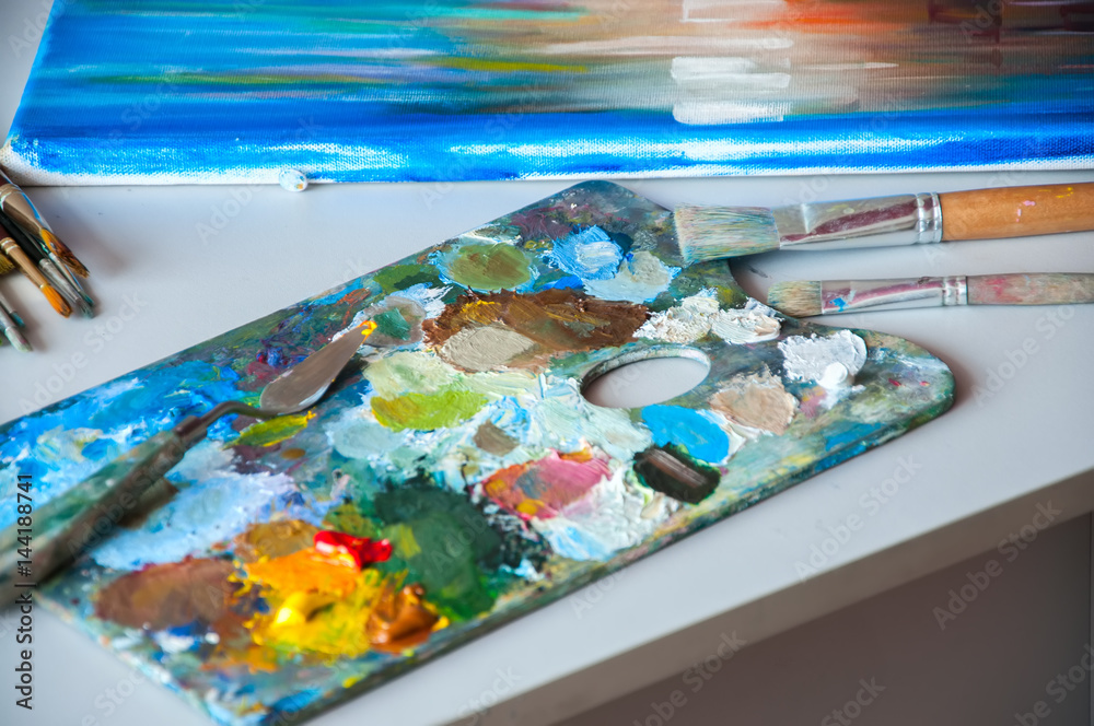 Art brushes and palette with oil paints on a table. Painting concept. Art brushes and palette with oil paints on a table. Painting concept.