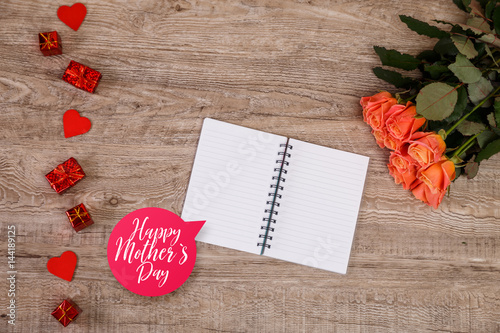 Pink roses with hearts and gift boxes. Happy Mothers day concept. Love design with notebook. Wooden rustic board.
