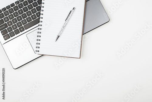 Top view of notepad and pen on laptop keyboard. Horizontal shoot.