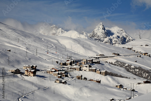 View of Trepalle village the highest town in Italy in winter with the tops of Livigno Valley windswept. Valtellina. Lombardy Italy Europe photo