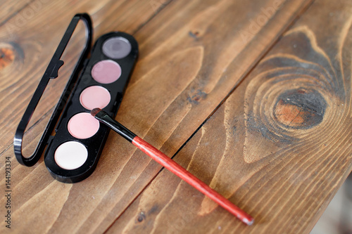 Palette with a brush on wooden background