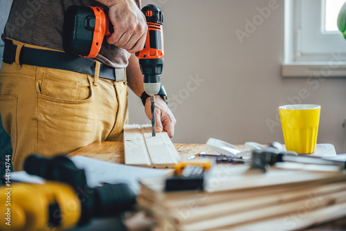 Man drilling wood with cordless drill