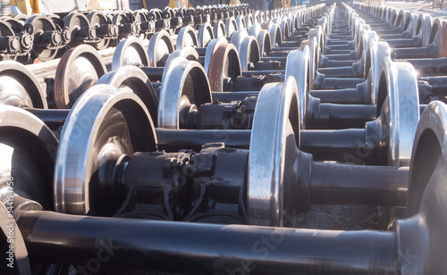 Photos New and spare railway wheels on the axle in a repair workshop